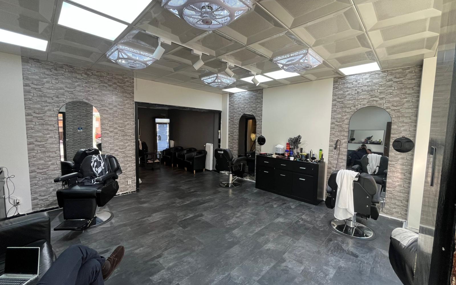 Salongen inifrån med barberarstolar och stenväggar